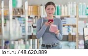 Positive young girl customer scanning QR on pills box held in hand in chemistry. Стоковое видео, видеограф Яков Филимонов / Фотобанк Лори