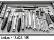 Variety of hand tools and accessories arranged on a workbench surface. Разнообразные ручные инструменты и принадлежности, разложенные на поверхности верстака. Стоковое AI-изображение, AI-художник Katsiaryna Repich / Фотобанк Лори