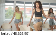 Group of women in high heels rehearsing dance while leaning on chair in dance studio. Стоковое видео, видеограф Яков Филимонов / Фотобанк Лори