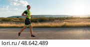 Triathlete in professional gear running early in the morning, preparing for a marathon, dedication to sport and readiness to take on the challenges of a marathon. Стоковое фото, фотограф Benis Arapovic / PantherMedia / Фотобанк Лори
