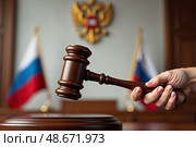 Церемониальный молоток судьи в момент вынесения приговора. В зале суда присутствуют флаги и символы правосудия, подчеркивающие важность момента. Стоковое AI-изображение, AI-художник Сергей Никифоров-Гордеев / Фотобанк Лори