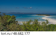 Beautiful tropical seascape. A winding sandbar leads to a small green island. Boats in the aquamarine ocean. Tiny silhouettes of people on the beach. Madagascar. Nosy Iranja. Blue sky, clouds. Стоковое фото, фотограф Вера Ивановна Кубарева / Фотобанк Лори