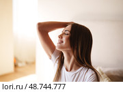 Woman enjoying a moment of relaxation at home during the morning sunlight. Стоковое фото, фотограф Сергей Толмачёв / Фотобанк Лори