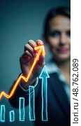Growing business in times of crisis. Business woman draws growth arrow graph chart. Global business industry development. Recovery business, development to success, profit and grow. Стоковое AI-изображение, AI-художник Sergey Grishin / Фотобанк Лори