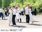 Выпускники школы танцуют вальс на школьном дворе. Редакционное фото, фотограф Васильева Юлия / Фотобанк Лори