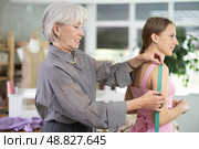Mature tailoress measuring female client in sewing workshop. Стоковое фото, фотограф Яков Филимонов / Фотобанк Лори