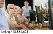 Friendly elderly computer course teacher helping senior woman learn computer. Стоковое видео, видеограф Яков Филимонов / Фотобанк Лори