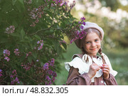 Vintage women's accessories and retro-style clothing. A small, beautiful girl with bows in her hair, in a beige dress and a beret outdoors. Стоковое фото, фотограф Photojuli / Фотобанк Лори