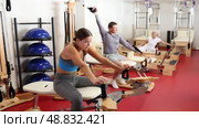 Young woman stretching her arms using pilates machine. Стоковое видео, видеограф Яков Филимонов / Фотобанк Лори