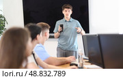 Young male speaker holds mobile phone in hands and explains to listeners of computer courses. Стоковое видео, видеограф Яков Филимонов / Фотобанк Лори