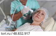 Using cosmetic workstation, male physician enhances the woman's features through tailored procedures. Стоковое видео, видеограф Яков Филимонов / Фотобанк Лори