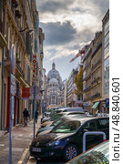 Marseille, France - Nov 3 2018, vertical view of a narrow street filled with parked cars, in the background Cathédrale Sainte-Marie-Majeure de Marseille, at daytime with cloudy sky, Marseille, France. Редакционное фото, фотограф Сергей Богомяко / Фотобанк Лори