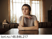 Молодая женщина сидит за столом и мечтает. Стоковое фото, фотограф Дмитрий Киселёв / Фотобанк Лори