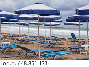 Безлюдный песчаный пляж в штормовую погоду. Sandy beach, deck chairs and beach umbrellas in stormy weather. Стоковое фото, фотограф Лариса Гордеева / Фотобанк Лори