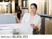 woman is considering MDF boards for internal insulation of residential premises. Стоковое фото, фотограф Яков Филимонов / Фотобанк Лори