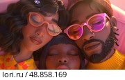A close-up image of three friends, two women and one man, wearing sunglasses and napping close together. They appear to be relaxed and enjoying each others company. Стоковое AI-изображение, AI-художник Данила Большаков / Фотобанк Лори