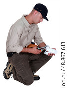 Plumber using pliers to fasten two parts together. Стоковое фото, агентство Ingram Publishing / Фотобанк Лори