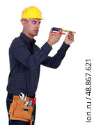 Man looking at his measuring tape surprisingly. Стоковое фото, агентство Ingram Publishing / Фотобанк Лори