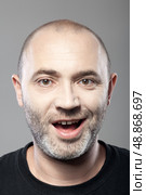portrait of ironical smiling man isolated on gray background. Стоковое фото, агентство Ingram Publishing / Фотобанк Лори