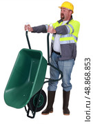 Tradesman emptying a wheelbarrow. Стоковое фото, агентство Ingram Publishing / Фотобанк Лори
