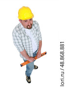 Construction worker with a spirit level. Стоковое фото, агентство Ingram Publishing / Фотобанк Лори