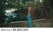 Woman with extremely long hair walking near a mangrove lagoon cenote in Mexico. Стоковое видео, видеограф Igor Tichonow / Фотобанк Лори