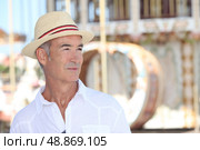Elderly man standing in front of a carousel. Стоковое фото, агентство Ingram Publishing / Фотобанк Лори