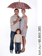 Family with an open umbrella. Стоковое фото, агентство Ingram Publishing / Фотобанк Лори