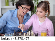 Mother and daughter playing chess. Стоковое фото, агентство Ingram Publishing / Фотобанк Лори