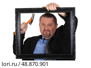 Businessman with a hammer and  frame. Стоковое фото, агентство Ingram Publishing / Фотобанк Лори