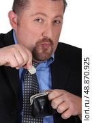 close up shot of moonfaced man with lady&rsquo;s purse. Стоковое фото, агентство Ingram Publishing / Фотобанк Лори