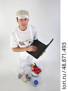 High-angle shot of a painter using his laptop. Стоковое фото, агентство Ingram Publishing / Фотобанк Лори