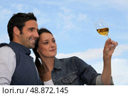 Couple looking at a glass of wine. Стоковое фото, агентство Ingram Publishing / Фотобанк Лори