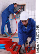 laborers installing tube. Стоковое фото, агентство Ingram Publishing / Фотобанк Лори
