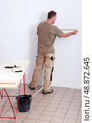 Man measuring wall. Стоковое фото, агентство Ingram Publishing / Фотобанк Лори