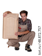 woodworker holding a window frame. Стоковое фото, агентство Ingram Publishing / Фотобанк Лори