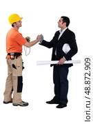 Engineering forming a pact with a tradesman. Стоковое фото, агентство Ingram Publishing / Фотобанк Лори