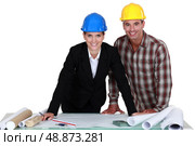 Architect stood with foreman going over plans. Стоковое фото, агентство Ingram Publishing / Фотобанк Лори