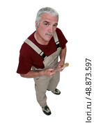 Top-view of middle-aged painter holding brush. Стоковое фото, агентство Ingram Publishing / Фотобанк Лори