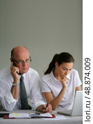 A grumpy businessman sitting beside his assistant. Стоковое фото, агентство Ingram Publishing / Фотобанк Лори