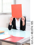 Smart woman hiding behind folder. Стоковое фото, агентство Ingram Publishing / Фотобанк Лори