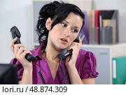 Woman dealing with two phone calls. Стоковое фото, агентство Ingram Publishing / Фотобанк Лори