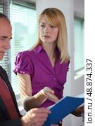Businesswoman explaining document to colleague. Стоковое фото, агентство Ingram Publishing / Фотобанк Лори