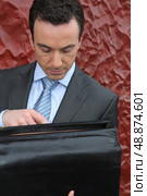 Businessman looking in his briefcase. Стоковое фото, агентство Ingram Publishing / Фотобанк Лори