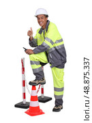Man in high visibility overalls with a traffic cone and barrier. Стоковое фото, агентство Ingram Publishing / Фотобанк Лори