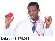 Doctor holding a stethoscope and a plastic heart. Стоковое фото, агентство Ingram Publishing / Фотобанк Лори