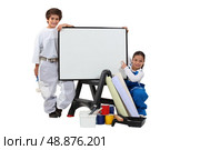 two children dressed in housepainter and a whiteboard. Стоковое фото, агентство Ingram Publishing / Фотобанк Лори
