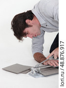 Man using a tile cutter. Стоковое фото, агентство Ingram Publishing / Фотобанк Лори