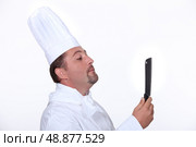 Chef looking at his reflection in a knife. Стоковое фото, агентство Ingram Publishing / Фотобанк Лори