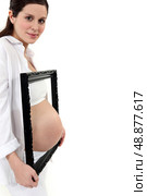 Pregnant woman with picture frame. Стоковое фото, агентство Ingram Publishing / Фотобанк Лори